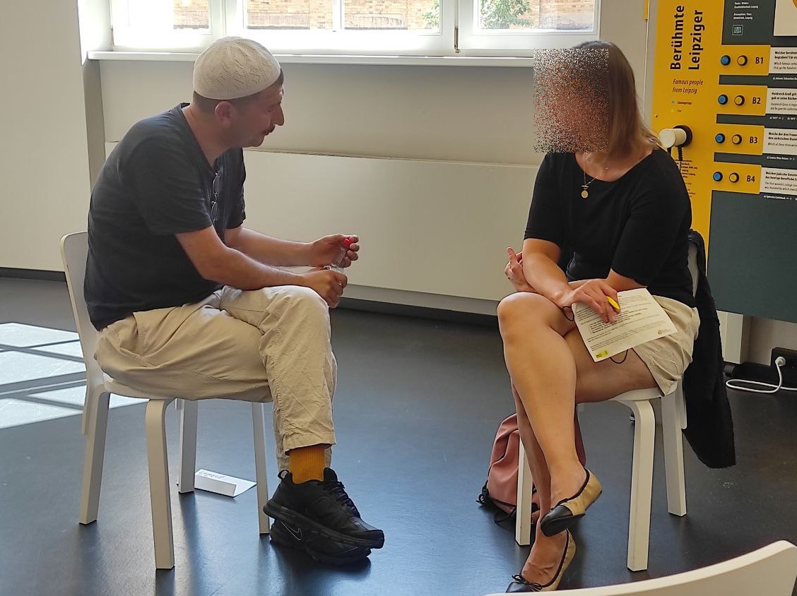 ein "human book" spricht mit einem Gast in der Stadtbibliothek Leipzig